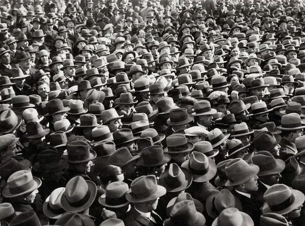 Fotografía histórica de una multitud en Madrid en la que prácticamente todos los hombres llevan sombrero, bombín, gorra o boina.
